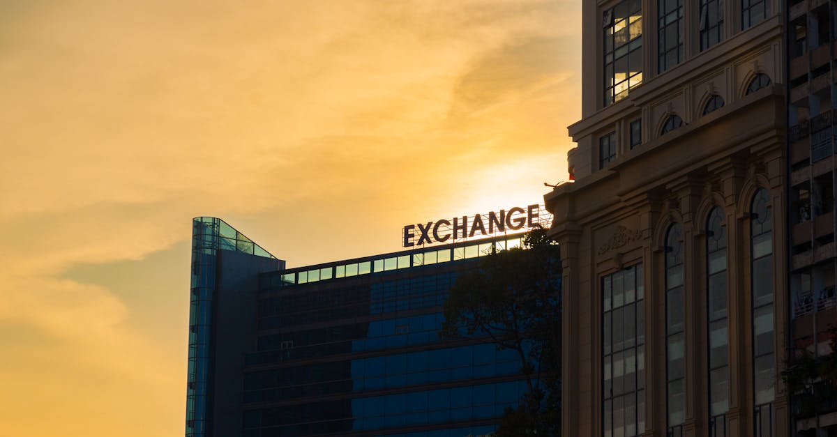 Silhouette of modern office building with 'EXCHANGE' sign during sunset.