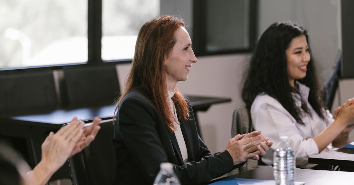 Business professionals engaged in a positive meeting, clapping in appreciation.