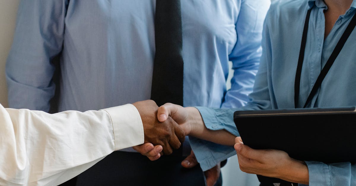 Close-up of business professionals shaking hands during a meeting in a modern office.