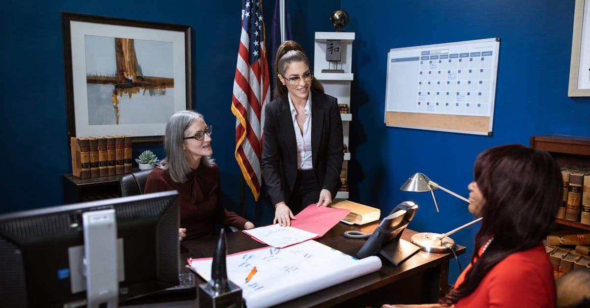 Three professional women in a business meeting discussing paperwork in a well-appointed office.