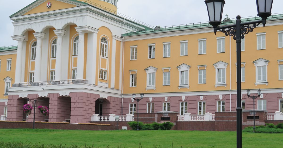 Stunning neoclassical architecture with tall columns and lush green lawn.
