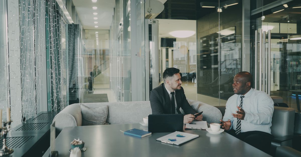 Two businessmen discussing strategy in a contemporary office environment.