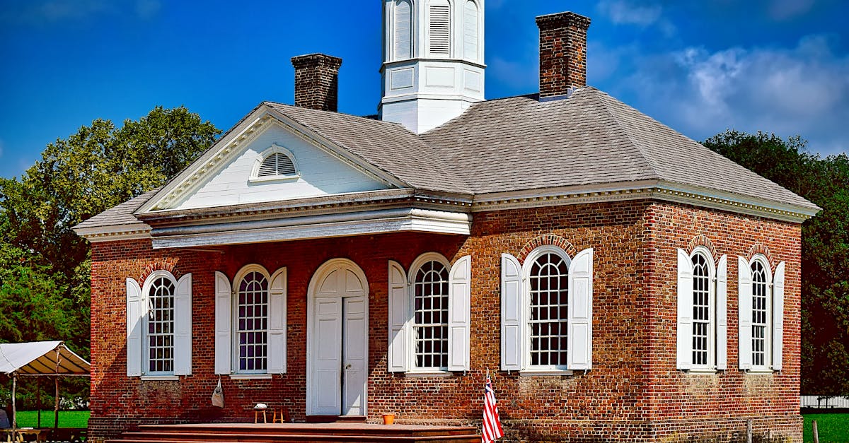 Colonial-style brick building with shutters and cupola in Williamsburg, USA.